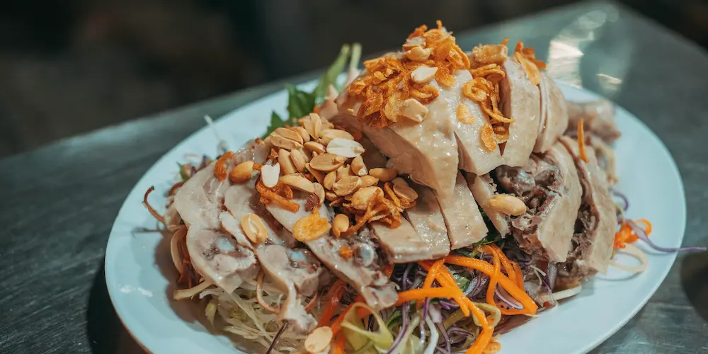 Разные варёные части курицы — грудка, голени и целая тушка — на тарелке