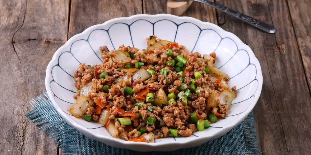Cooked ground beef crumbles drained on a plate lined with paper towel