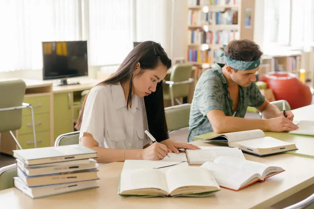 Students studying with open textbooks in a library — focused study sessions with breaks